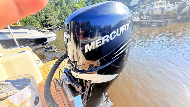 Slide: The Image of A Mercury outboard motor on a Scout 235 XSF boat docked at a calm waterfront. - 16