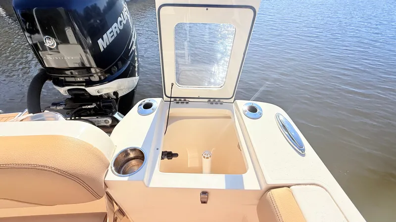 Slide: The Image of A 2018 Scout 235 XSF with an open storage compartment and a Mercury engine in the background. - 15