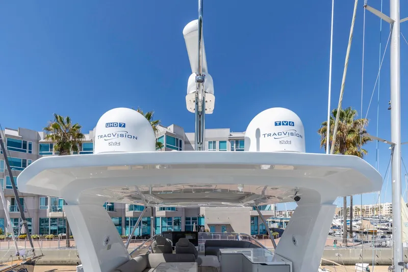Slide: The Image of 2021 Azimut Fly 60 yacht with TracVision satellite domes, docked near modern buildings. - 18