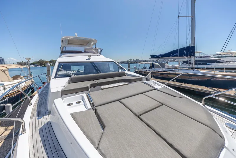 Slide: The Image of 2021 Azimut Fly 60 yacht with spacious deck, docked in a marina under clear blue skies. - 33