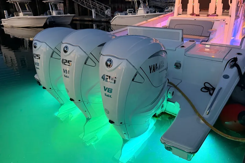 Slide: The Image of 2022 Pursuit S 378 Sport boat with triple Yamaha 425 V8 engines, illuminated in water. - 49