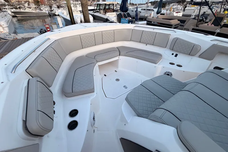 Slide: The Image of 2022 Pursuit S 378 Sport boat with luxurious seating and modern design at a marina. - 7