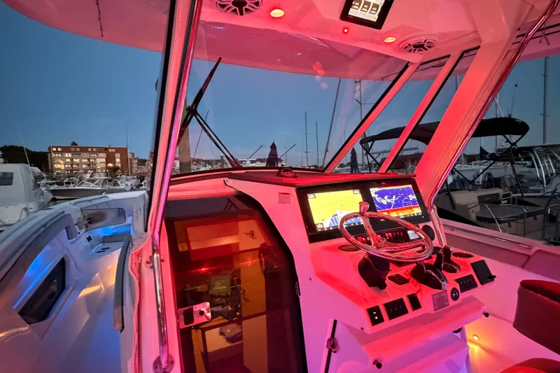 Slide: The Image of 2022 Pursuit S 378 Sport boat cockpit with illuminated controls and navigation screens. - 20