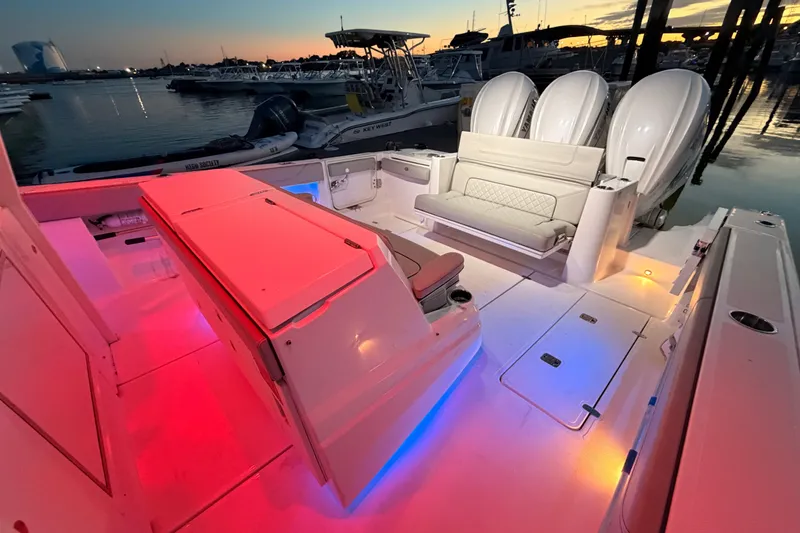 Slide: The Image of 2022 Pursuit S 378 Sport boat interior with colorful LED lighting at sunset. - 29