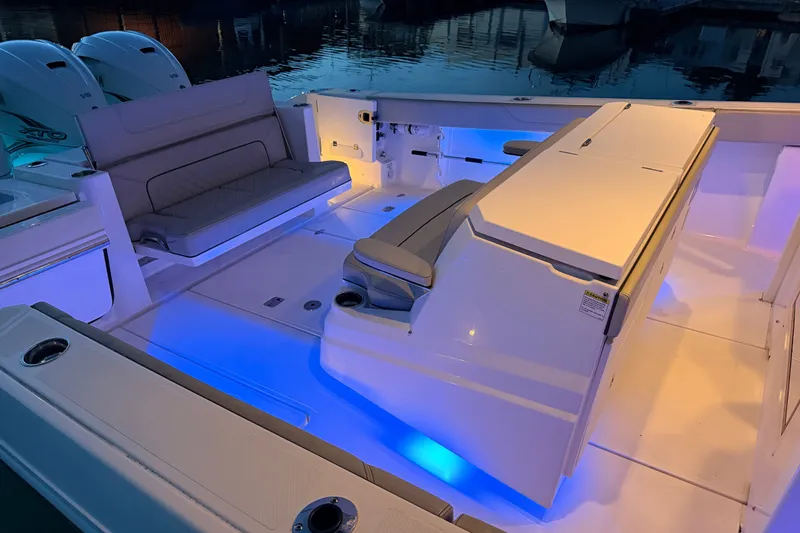 Slide: The Image of 2022 Pursuit S 378 Sport boat interior with blue LED lighting and seating. - 34