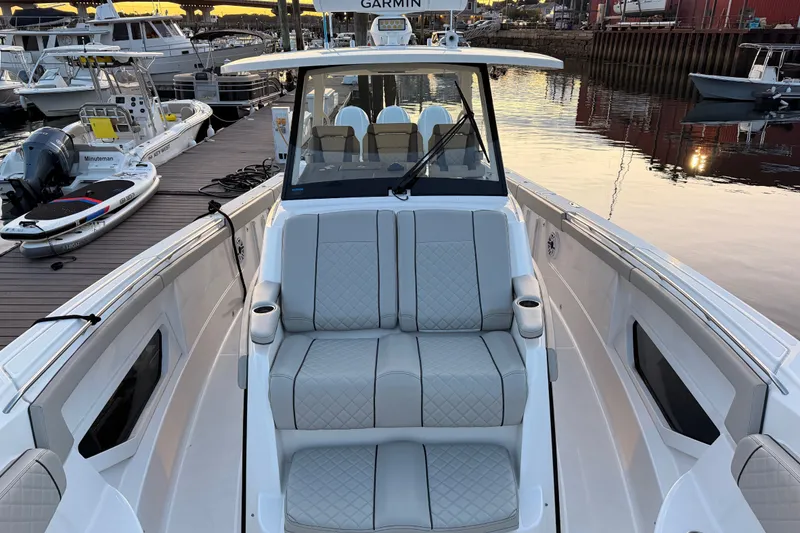Slide: The Image of 2022 Pursuit S 378 Sport boat with luxurious seating at a marina dock. - 11