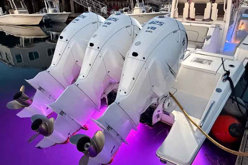 Slide: The Image of Triple outboard engines on a 2022 Pursuit S 378 Sport boat with purple underwater lighting. - 47