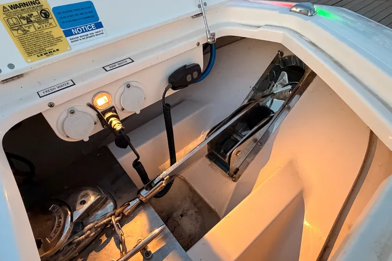 Slide: The Image of 2022 Pursuit S 378 Sport boat anchor compartment with controls and warning labels. - 40