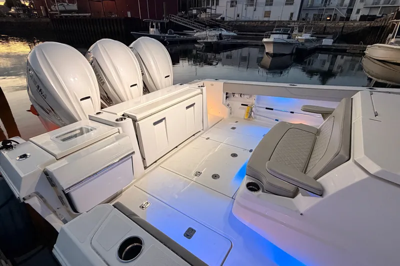 Slide: The Image of 2022 Pursuit S 378 Sport boat interior with seating and triple outboard engines at dock. - 44
