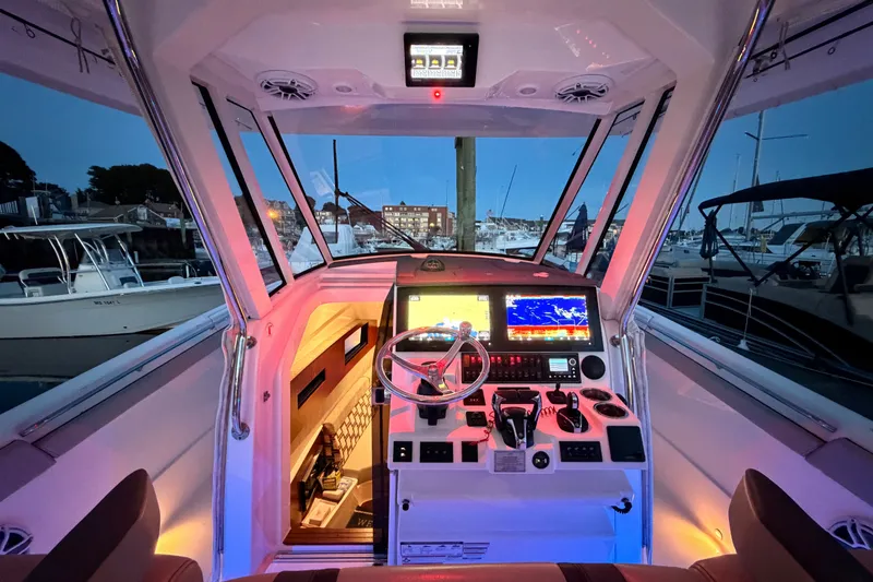 Slide: The Image of Cockpit of 2022 Pursuit S 378 Sport boat with illuminated controls and navigation screens. - 25