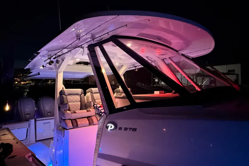 Slide: The Image of 2022 Pursuit S 378 Sport boat illuminated at night, showcasing luxury seating and design. - 22