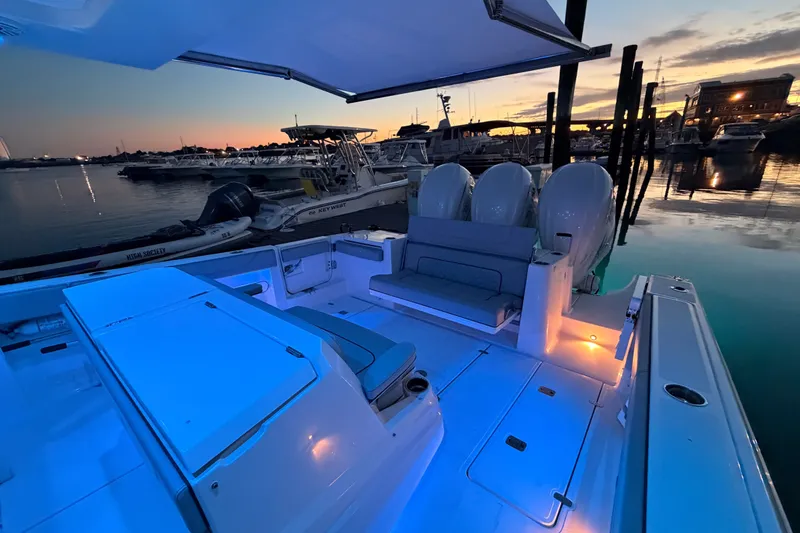 Slide: The Image of 2022 Pursuit S 378 Sport boat at sunset, illuminated deck, marina background. - 31