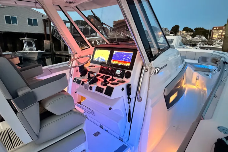 Slide: The Image of 2022 Pursuit S 378 Sport boat cockpit with illuminated controls and modern navigation system. - 17