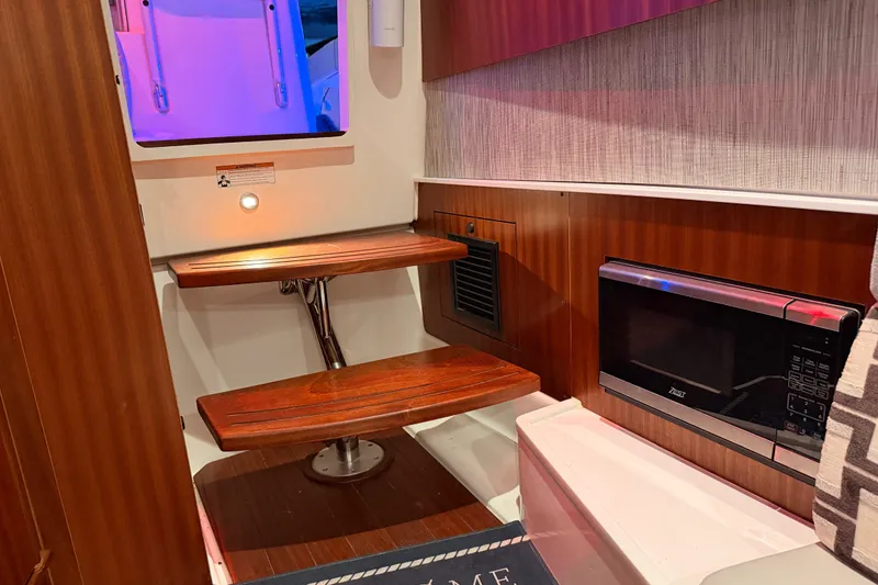 Slide: The Image of Interior of 2022 Pursuit S 378 Sport boat with wooden steps and microwave. - 52