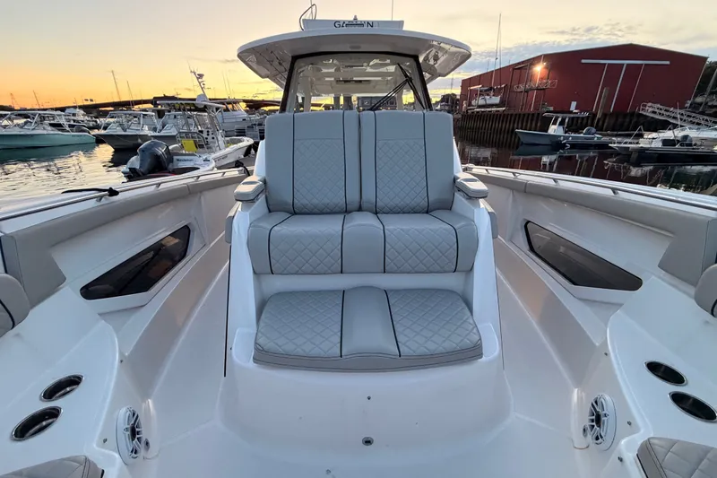 Slide: The Image of 2022 Pursuit S 378 Sport boat interior with luxurious seating at sunset in marina. - 10