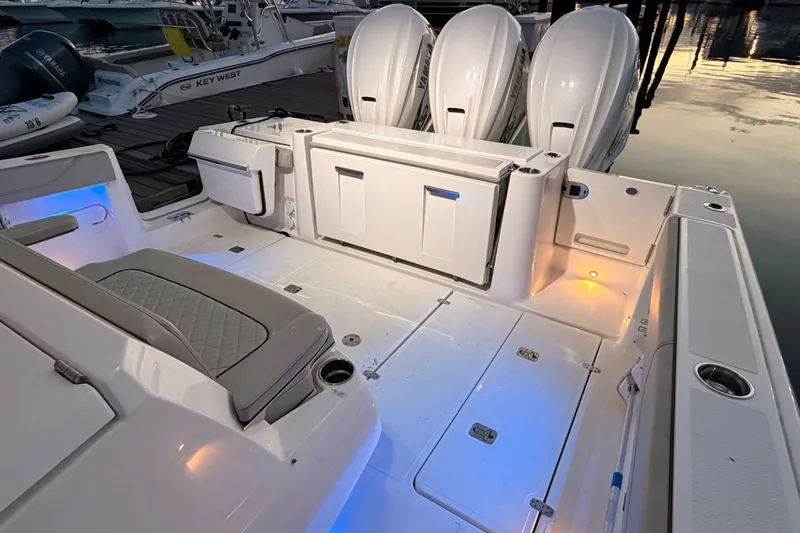 Slide: The Image of 2022 Pursuit S 378 Sport boat interior with seating and outboard engines at dock. - 26