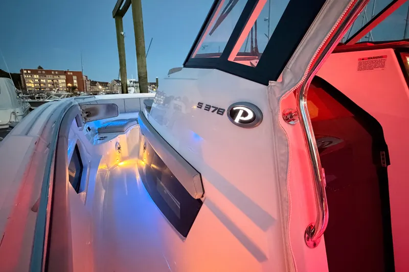 Slide: The Image of 2022 Pursuit S 378 Sport boat with colorful deck lighting at dusk. - 18
