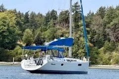 Slide: The Image of 2013 Jeanneau Sun Odyssey 44i sailboat on a serene lake with forested background. - 30