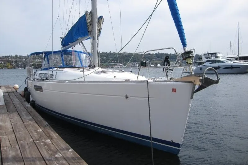 Slide: The Image of 2013 Jeanneau Sun Odyssey 44i sailboat docked at marina, featuring blue sail cover. - 33