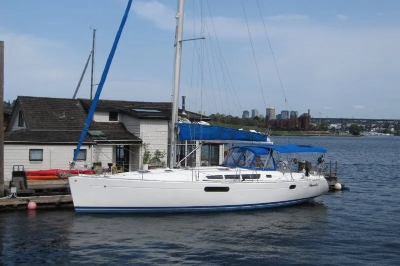The Image of 2013 Jeanneau Sun Odyssey 44i sailboat docked by waterfront house. - 0