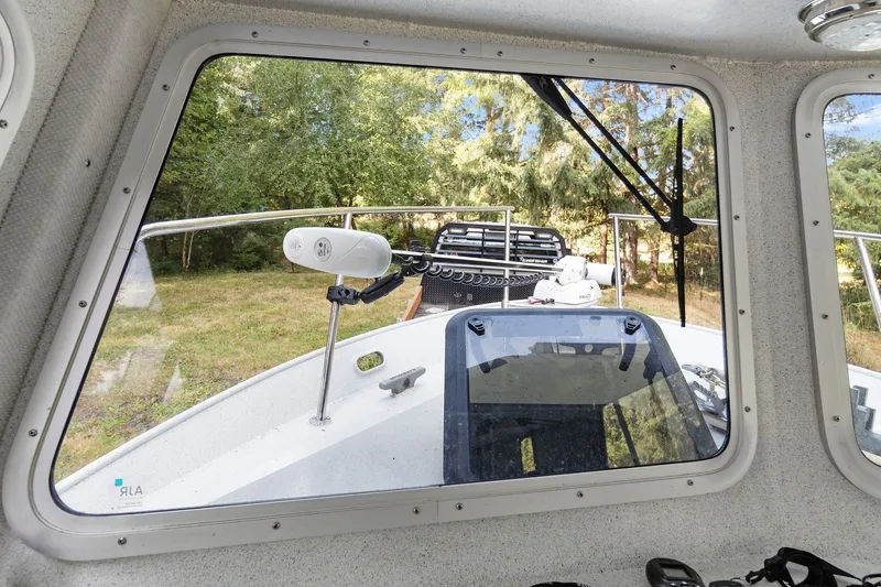 Slide: The Image of View from inside a 2021 KingFisher 2625 Coastal Express boat, showing the deck and greenery outside. - 40