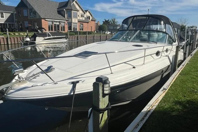 Slide: The Image of 2007 Sea Ray Sundancer 320 docked near waterfront homes under a clear blue sky. - 5
