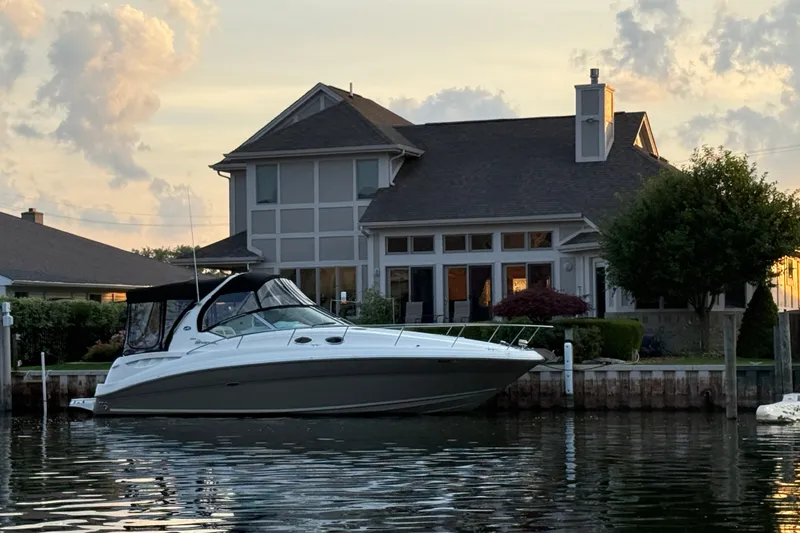 Slide: The Image of 2007 Sea Ray Sundancer 320 docked by a waterfront house at sunset. - 1
