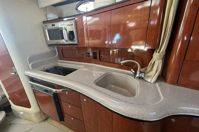 Slide: The Image of Interior of 2007 Sea Ray Sundancer 320 yacht kitchen with wood cabinets and appliances. - 36