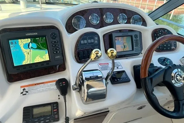 Slide: The Image of Control panel of a 2007 Sea Ray Sundancer 320 with navigation screens and steering wheel. - 18
