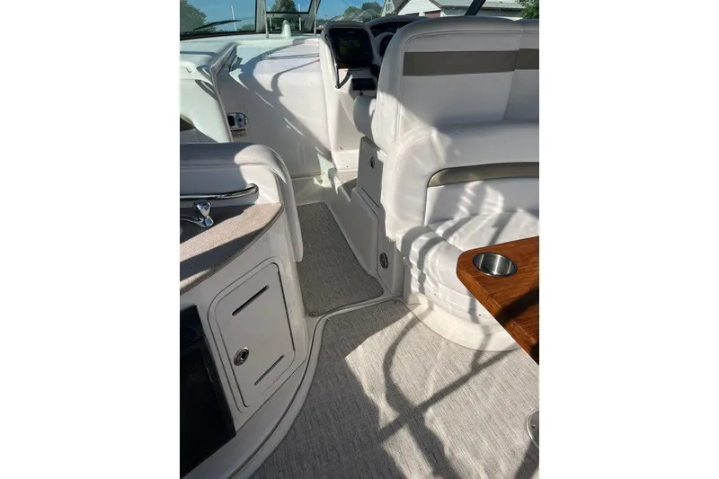 Slide: The Image of Interior of a 2007 Sea Ray Sundancer 320 boat, featuring white seating and a wooden table. - 23