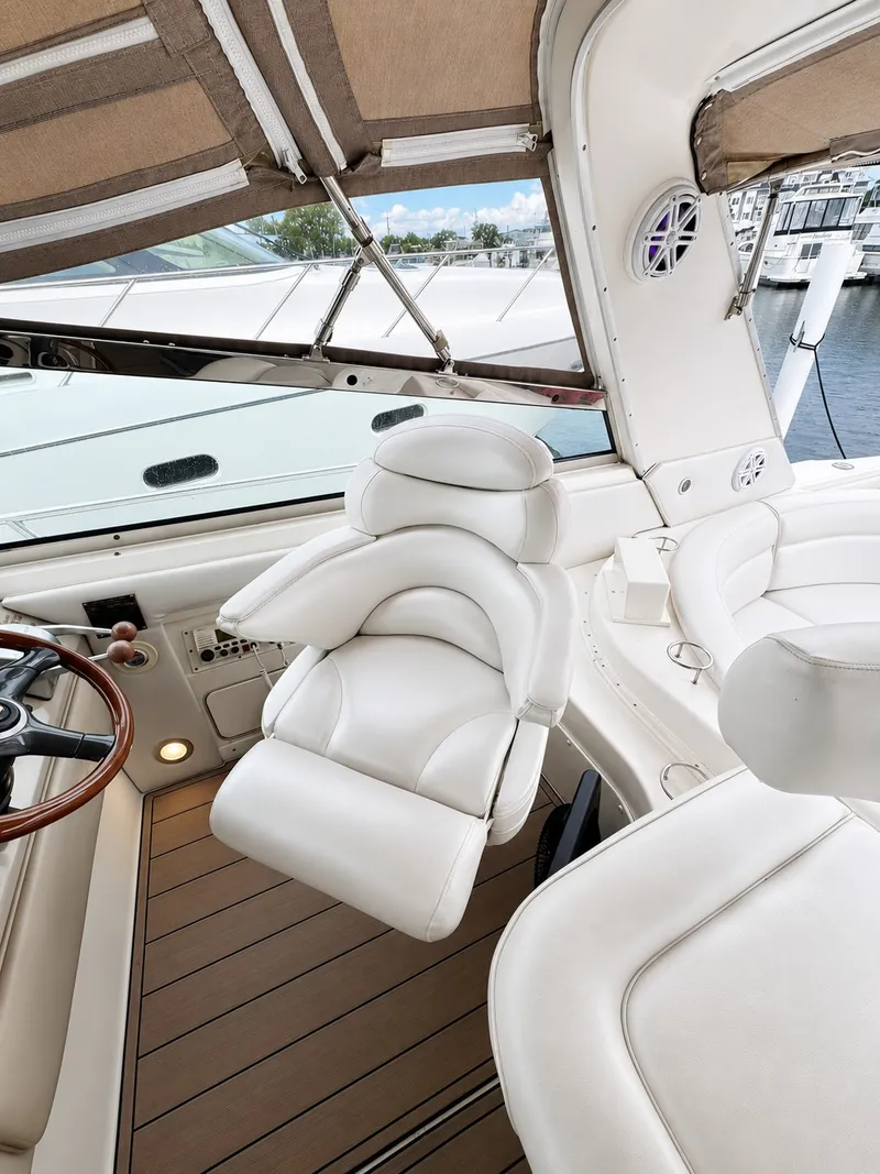 Slide: The Image of The image shows the helm of a 1999 Sea Ray 500 Sundancer with white leather seats. - 16