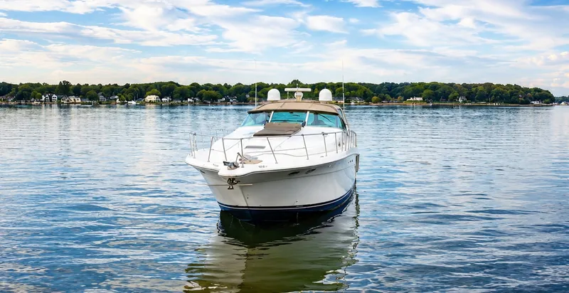 Slide: The Image of A 1999 Sea Ray 500 Sundancer on calm water with a wooded shoreline in the background. - 4
