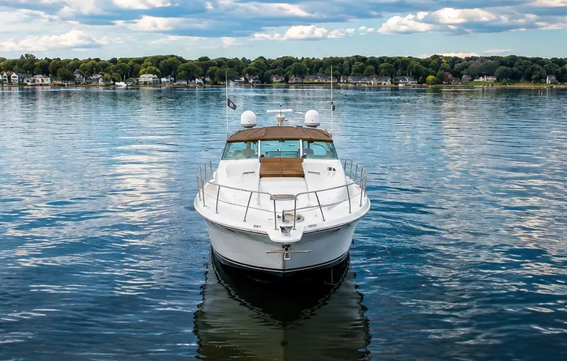 Slide: The Image of 1999 Sea Ray 500 Sundancer on calm water with a wooded shoreline in the background. - 5