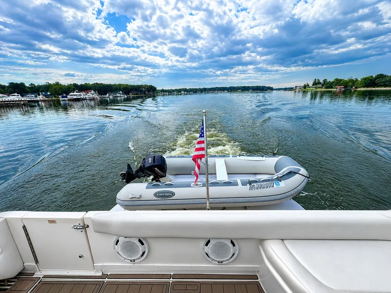 Slide: The Image of An inflatable boat with an outboard motor and American flag on a larger boat. - 18