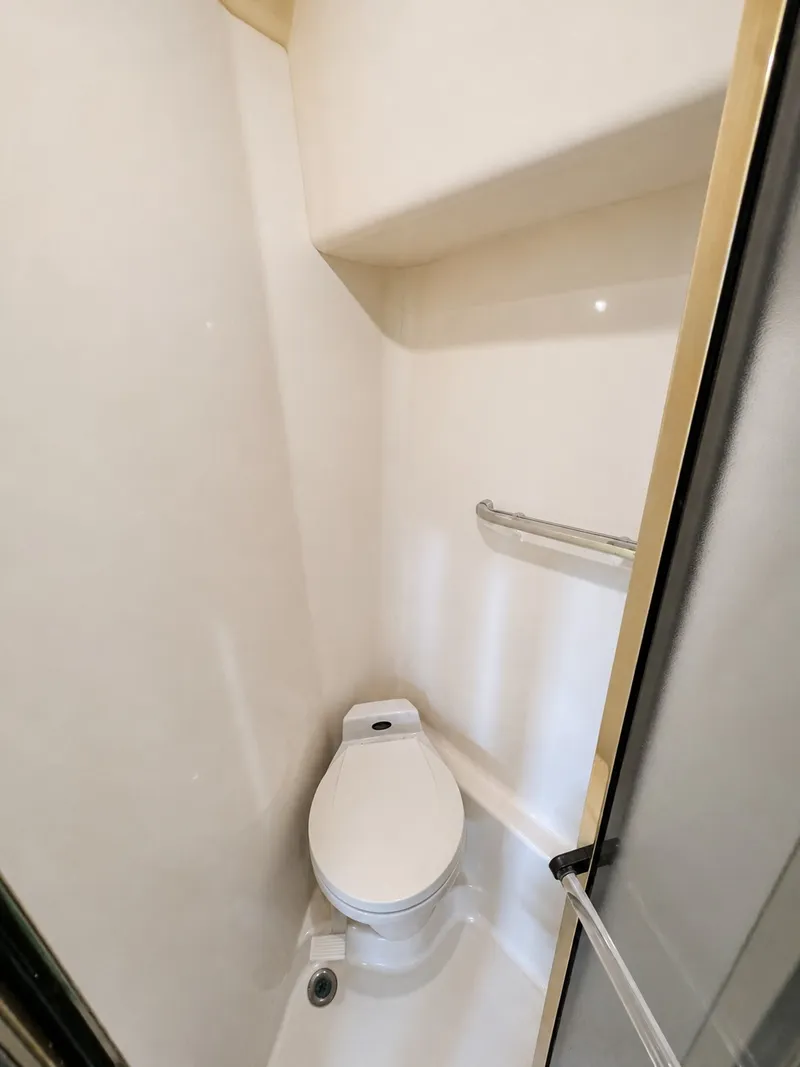 Slide: The Image of Compact bathroom with toilet and handrail in a 1999 Sea Ray 500 Sundancer. - 31