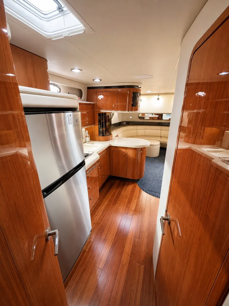 Slide: The Image of Interior of the 1999 Sea Ray 500 Sundancer with wood floors and modern kitchen. - 24
