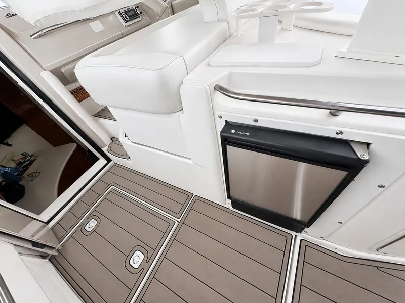 Slide: The Image of The image shows the interior of a 1999 Sea Ray 500 Sundancer with sleek wood flooring and a refrigerator. - 15