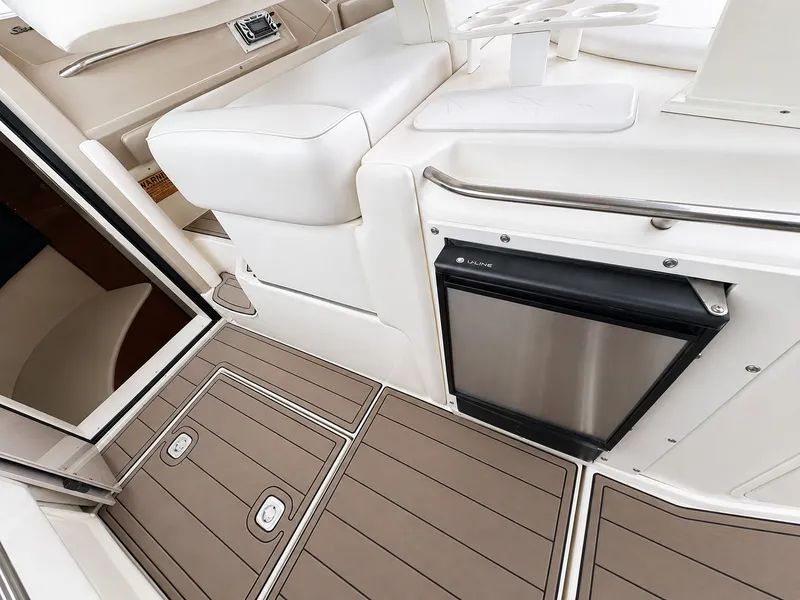 Slide: The Image of The image shows the interior of a 1999 Sea Ray 500 Sundancer with sleek seating and a refrigerator. - 19