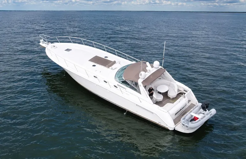 Slide: The Image of The 1999 Sea Ray 500 Sundancer is a sleek white boat on calm waters. - 11