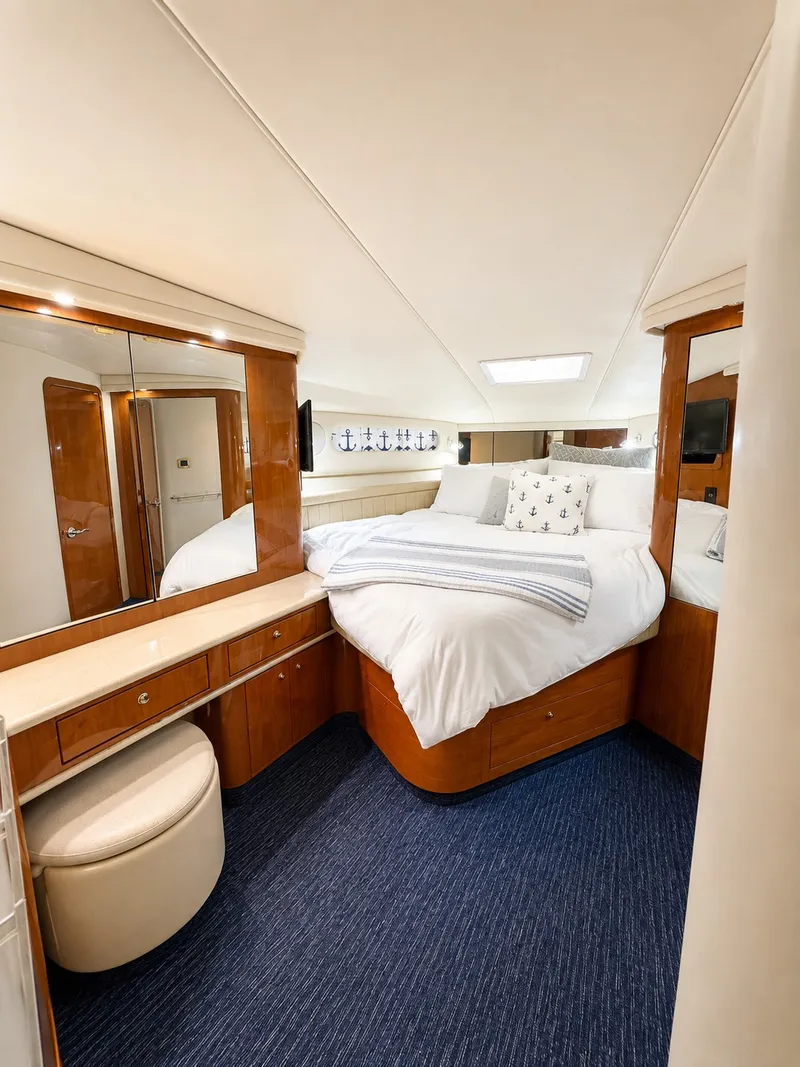 Slide: The Image of The image shows a luxurious cabin with a large bed, wooden furniture, and blue carpeting. - 25