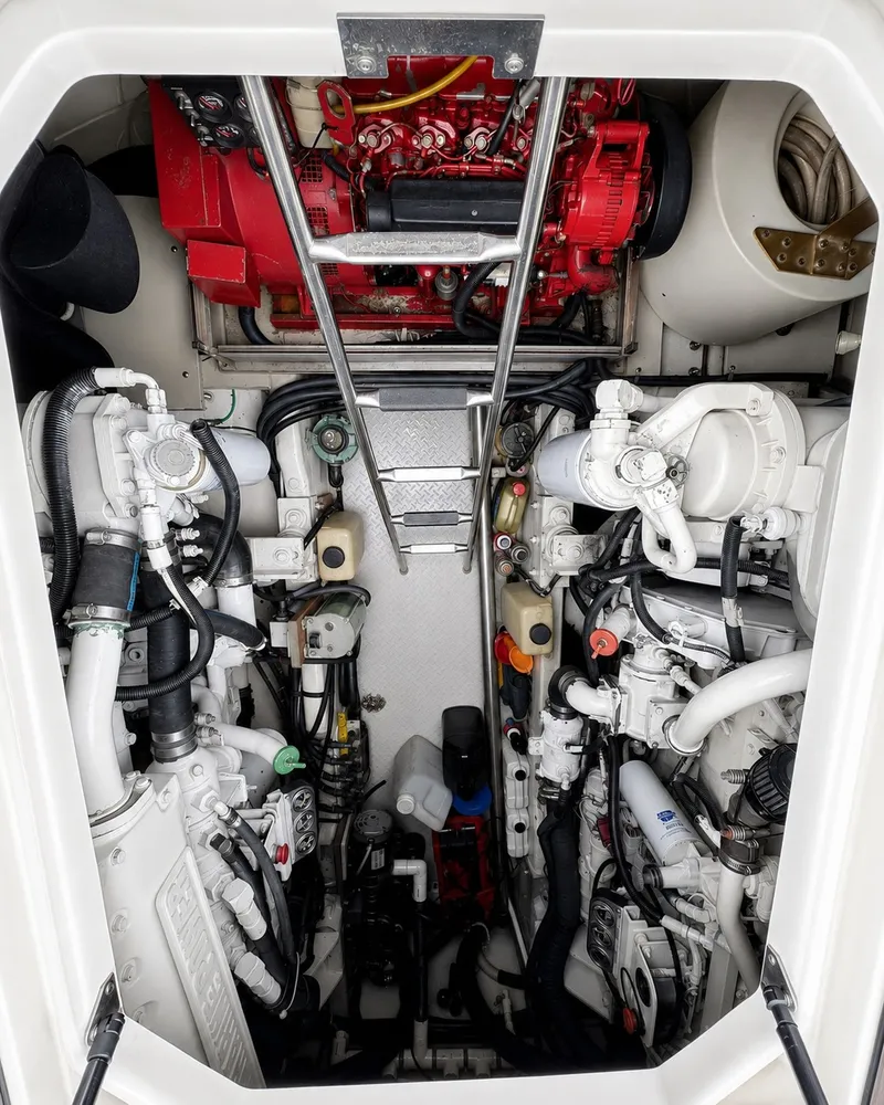Slide: The Image of The engine room of a 1999 Sea Ray 500 Sundancer with complex machinery and pipes. - 33