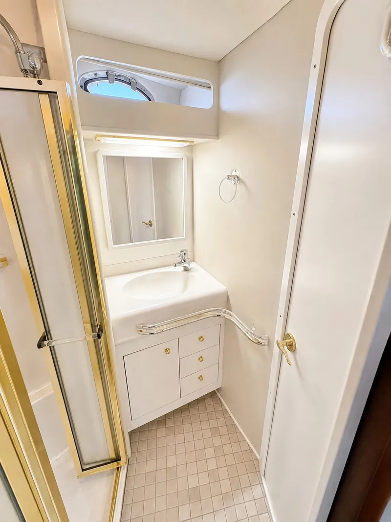 Slide: The Image of The image shows a boat bathroom with a shower, sink, and mirror. - 30