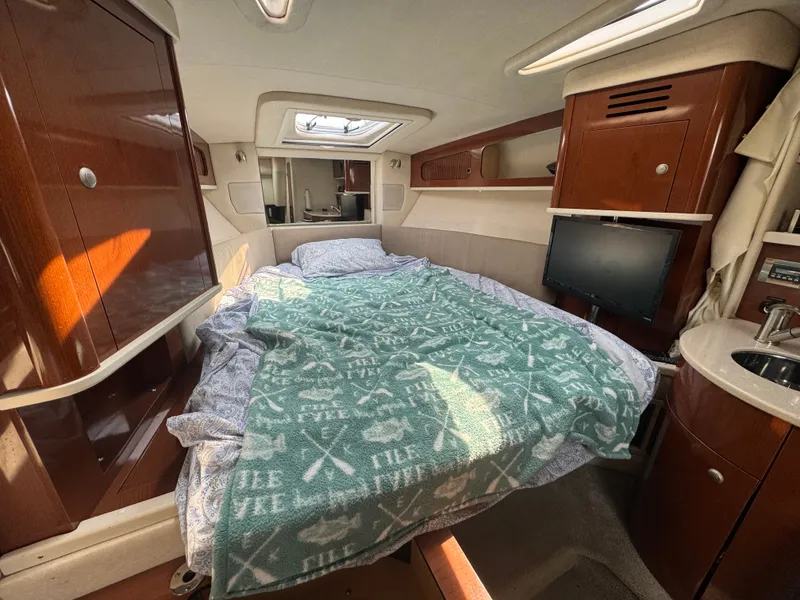Slide: The Image of Cabin of the 2008 Sea Ray 290 Sundancer with a double bed, TV, and sink. - 14