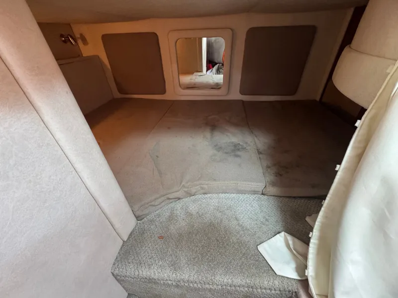 Slide: The Image of Interior of a 2008 Sea Ray 290 Sundancer with carpeted floor and padded walls. - 17