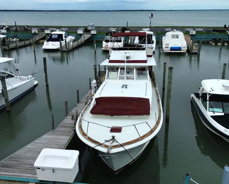 The Image of A 1971 Chris-Craft 47 Commander docked in a calm marina, surrounded by other boats. - 5
