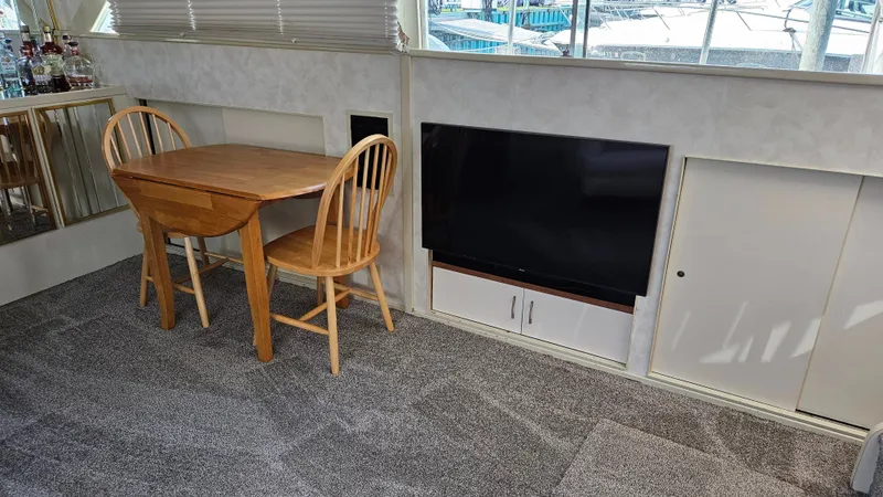 Slide: The Image of Interior of a boat with a wooden table, two chairs, and a wall-mounted TV. - 19