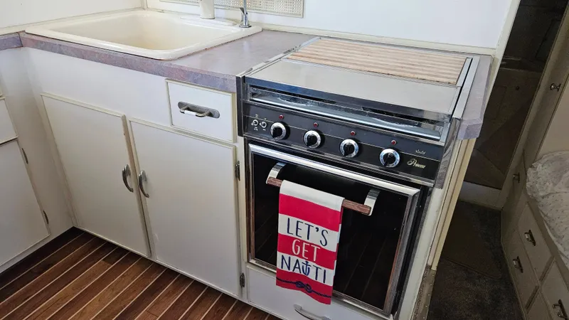 Slide: The Image of The galley of a 1971 Chris-Craft 47 Commander with a stove, sink, and cabinetry. - 29