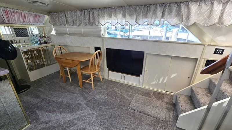 Slide: The Image of Interior of a 1971 Chris-Craft 47 Commander with carpeted floor, dining table, and large window. - 17