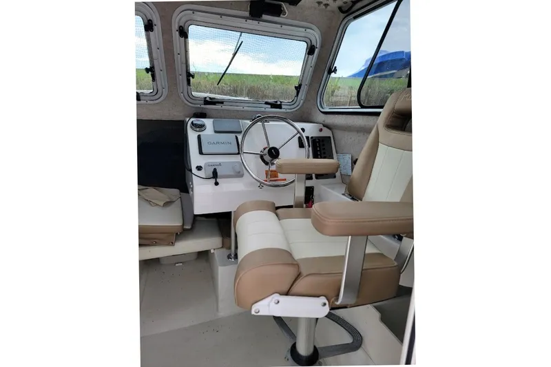 Slide: The Image of Interior of 2017 Parker 2120 Sport Cabin boat with steering wheel and Garmin equipment. - 9