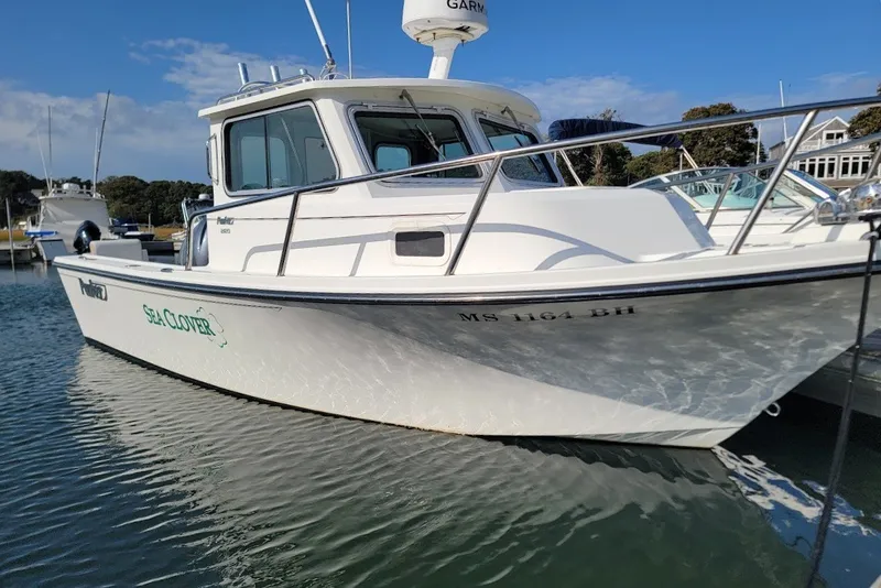 Slide: The Image of 2017 Parker 2120 Sport Cabin boat named "Sea Clover" docked in calm waters. - 1